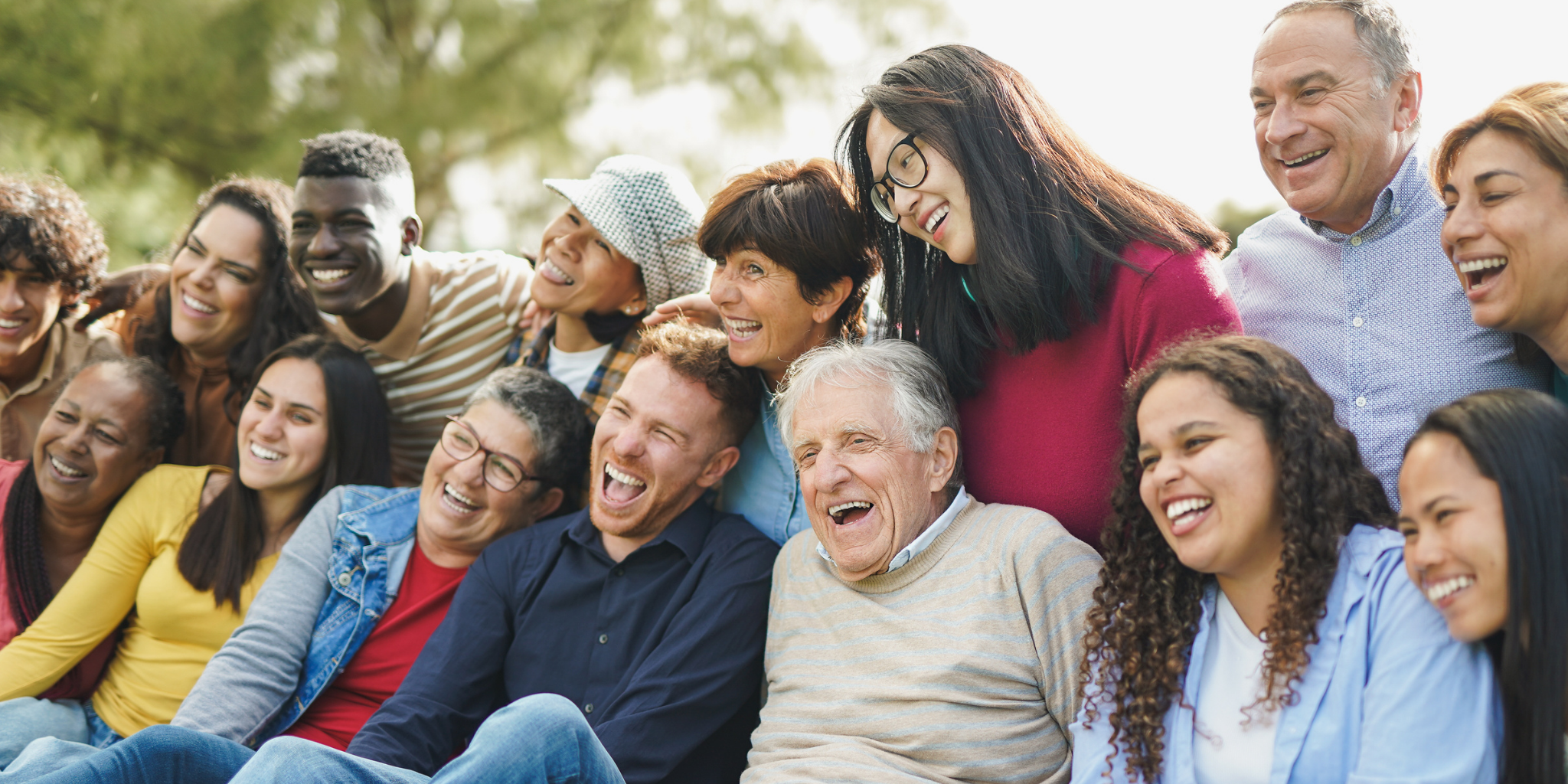 a diverse, multigeneration group smiling for a group photo
