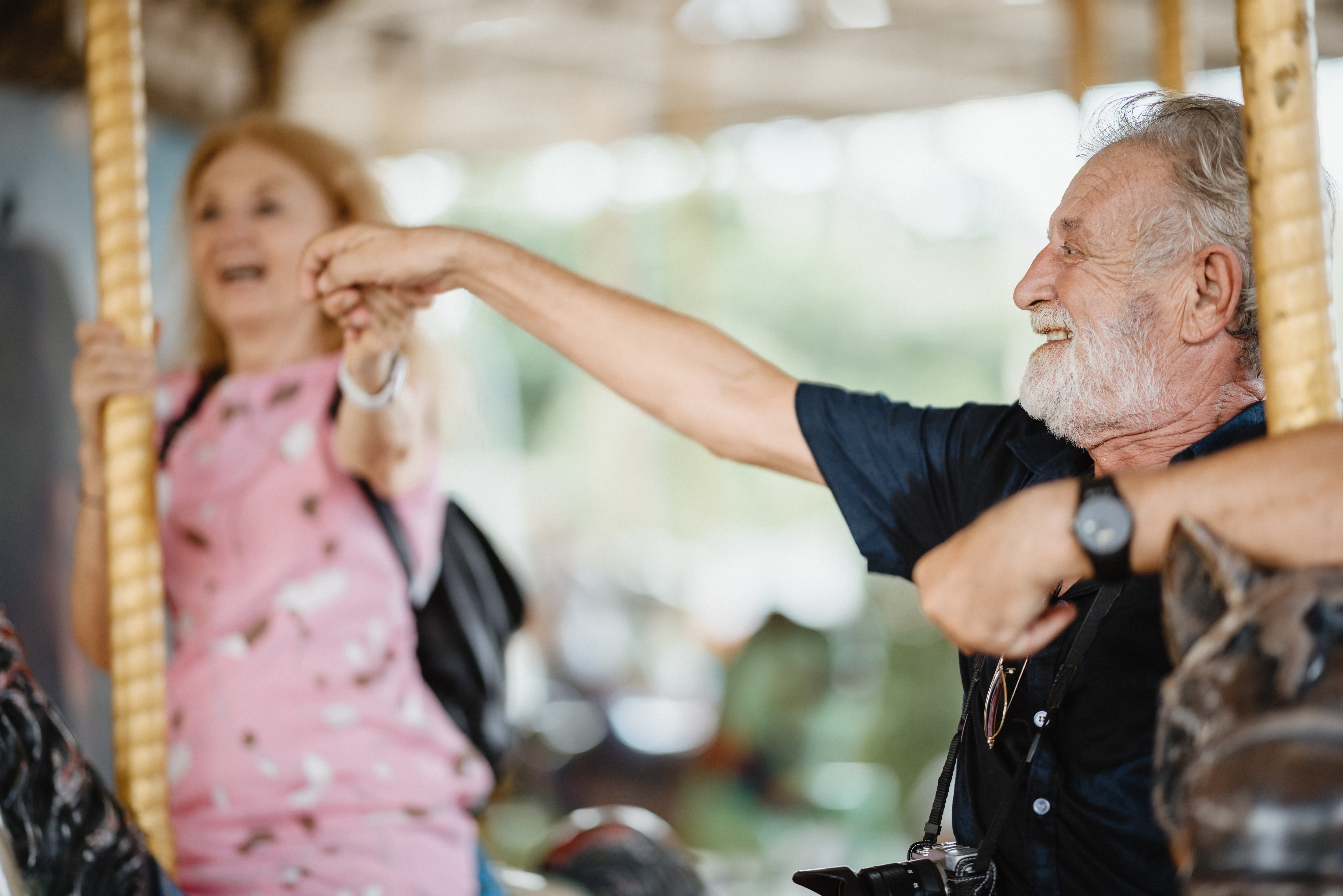 Senior couple enjoying a ride on a carousel with blurred background